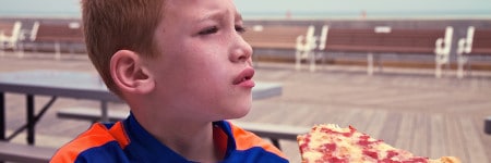 ילד אוכל פיצה