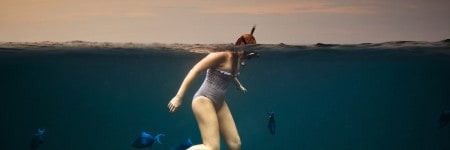 אישה שוחה עם דגים