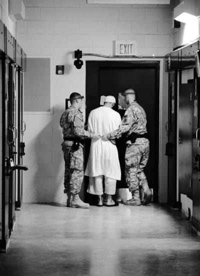אסיר וסוהרים באחד ממחנות המעצר בגואנטנמו.
