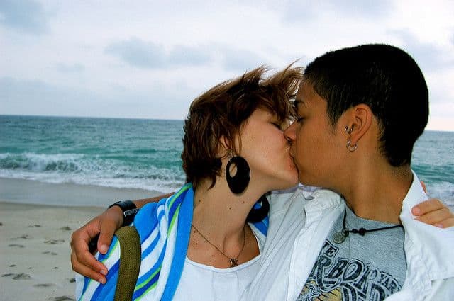 לסביות מתנשקות על החוף. בוץ', femme, butch